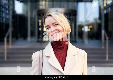 Donna caucasica bionda di mezza età che guarda felice di fotocamera. Bella signora matura sorridente. Foto Stock