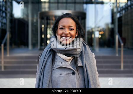 Giovane donna d'affari afroamericana che guarda la macchina fotografica sorridente. Signora allegra sorridente per i successi del lavoro. Foto Stock