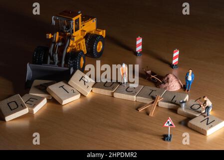 Figure in miniatura che demoliscono la parola 'distruzione' Foto Stock