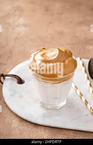 Dalgona ha montato il caffè con latte ghiacciato di latte o mandorle, caffè coreano alla moda drink Foto Stock