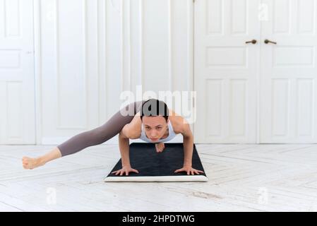 Insegnante di yoga femminile che pratica in studio. Donna che fa una mano. Foto Stock