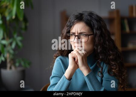 Giovane nervoso ha stressato femmina afflitta da preoccupazioni costanti e pensieri ansiosi mentre si siede a casa Foto Stock