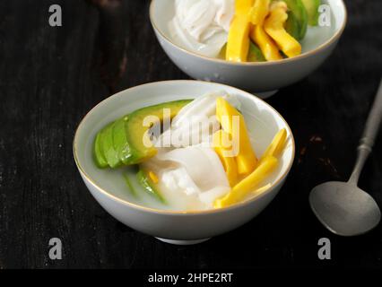 Es Teler, dessert di ghiaccio indonesiano tradizionale di cocktail di frutta tropicale in acqua dolce di cocco e latte condensato servito in ciotola Foto Stock