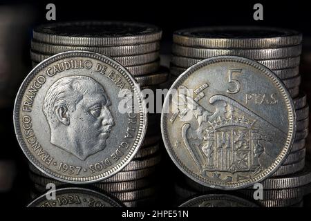 Francisco Franco Five pesetas Coin 1957 Obverse Reverse Close Up Coin Stacks Black background Foto Stock