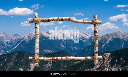 Splendida vista sulle montagne innevate da una cornice di legno Foto Stock