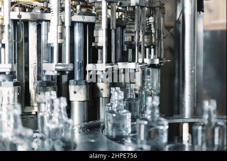 Riempimento di bottiglie di vetro con liquido. Foto Stock