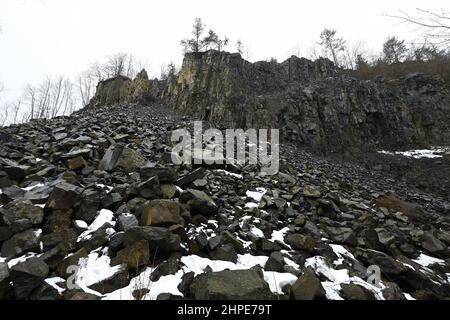 15 febbraio 2022, Hessen, Hoher Meißner: Vista del muro di pietra dell'ex miniera di lignite a pozzo aperto di Kalbe sul versante orientale dell'Hohe Meißner. Un fuoco di giunco è stato bruciante qui per i secoli. A causa di una reazione chimica, la lignite si infiamma da sola e bruciò. In determinate condizioni meteorologiche, l'odore di zolfo può essere percepito a chilometri di distanza. (A dpa 'carbone incandescente nella Hohe Meißner: Fuoco di giunco è stato bruciante per secoli') Foto: Uwe Zucchi/dpa Foto Stock