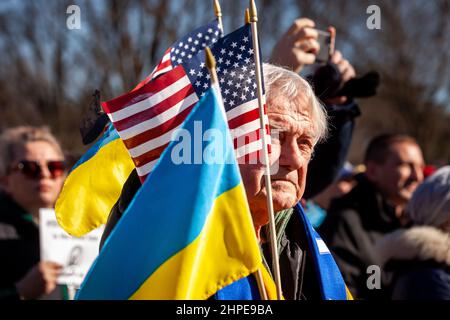 Washington, DC, USA, 20 Febbraio, 2022. Nell'immagine: Un manifestante detiene bandiere ucraine e americane durante un raduno di solidarietà per l'Ucraina. Migliaia di persone hanno partecipato all’evento per sostenere l’indipendenza, la sovranità e l’integrità territoriale dell’Ucraina mentre il presidente russo Vladimir Putin minaccia l’invasione delle truppe mobilitate al confine. L'evento è stato sponsorizzato da Razom, un'organizzazione di advocacy Ucraina, e ha incluso una veglia per i cento celesti / Nebesna Sotnia (quelli uccisi durante la Rivoluzione della dignità del 2014), così come una marcia alla Casa Bianca. Credit: Allison Bailey / Alamy Live News Foto Stock