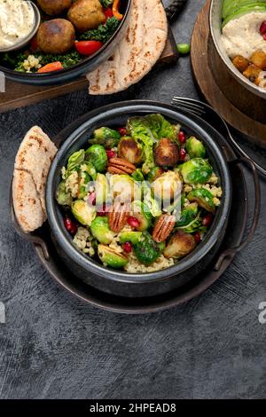 Insalata di germoglio con bulgur su sfondo scuro. Cibo vegano cocnept. Vista dall'alto, disposizione piatta, spazio di copia Foto Stock