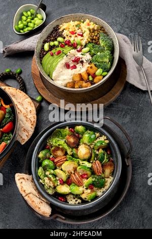 Insalata di germoglio con bulgur su sfondo scuro. Cibo vegano cocnept. Vista dall'alto, piatto Foto Stock