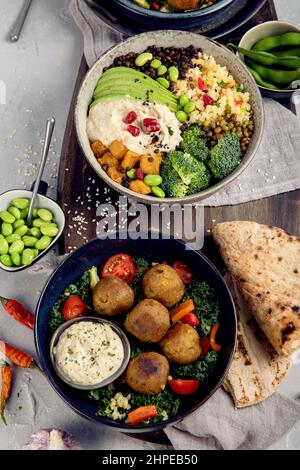 Assortimento di piatti vegani su sfondo chiaro. Concetto di dieta mediterranea. Disposizione piatta, vista dall'alto Foto Stock