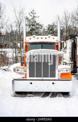 Trattore semi-camion professionale a lunga percorrenza Classic arancione Big RIG con cabina estesa in piedi senza semi-rimorchio per il riposo del conducente durante l'inverno t Foto Stock