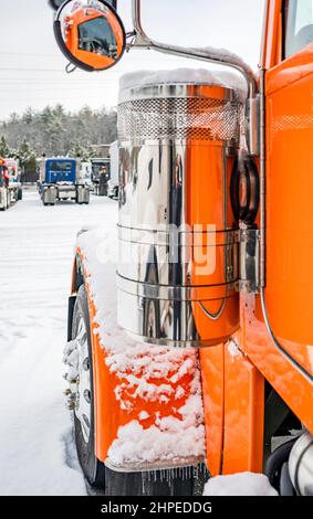 Trattore semi-camion professionale a lunga percorrenza Classic arancione Big RIG con cabina estesa in piedi senza semi-rimorchio per il riposo del conducente durante l'inverno t Foto Stock