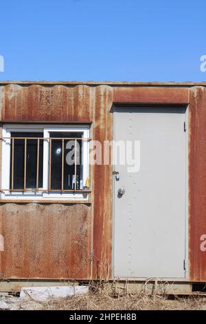 Ingresso anteriore della casa contenitore di spedizione arrugginita Foto Stock