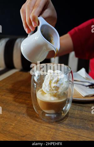 Primo piano Affogato, caffè espresso versato su una paletta gelato alla vaniglia Foto Stock