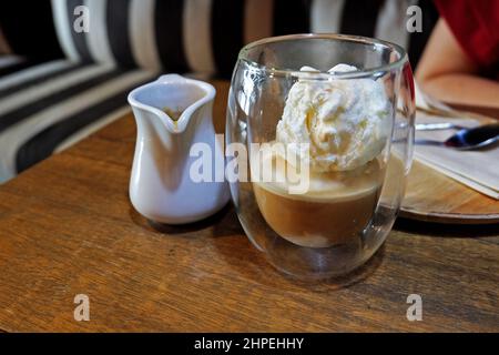 Primo piano Affogato, caffè espresso versato su una paletta gelato alla vaniglia Foto Stock