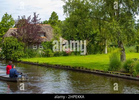 GIETHOORN, PAESI BASSI - AGOSTO 01 2017: Visitatori sconosciuti nel giro turistico in barca in un canale a Giethoorn. Le belle case e il giardinaggio Foto Stock