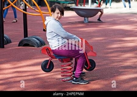 Ostersund, Norrland Svezia - 10 luglio 2020: Giovane ragazzo che gioca con il giocattolo a dondolo nel parco Foto Stock