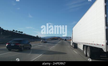 Autocarro o semirimorchio su autostrada, trasporto merci in California USA. Trasporto di container bianchi o trasporto su strada a autostrada. Logistica del trasporto commerciale, trasporto del furgone. Auto alla guida. Foto Stock