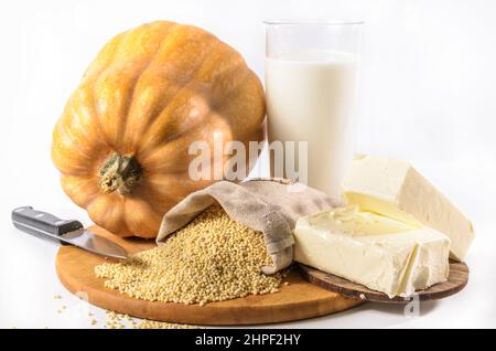 zucca, miglio e altri ingredienti per porridge di zucca su sfondo chiaro Foto Stock