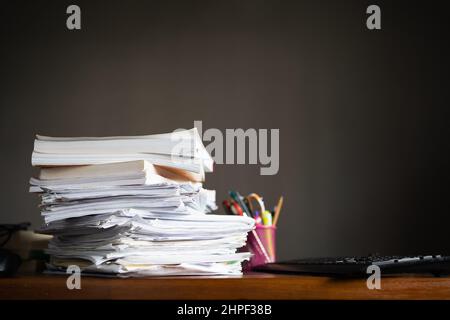 Una pila di fogli di carta e libri su un tavolo Foto Stock