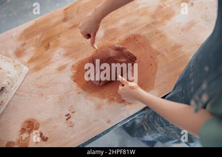Artista di ceramica femminile che prepara argilla per lo stampaggio in sala di lavoro Foto Stock