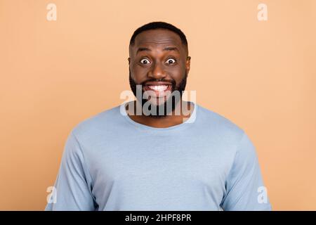 Ritratto di attraente allegro stordito ragazzo buona reazione di notizie isolato su sfondo beige color pastello Foto Stock