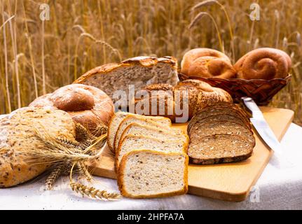 lotto di pane, grano, segale aromatizzato, sulla tavola all'esterno del campo Foto Stock