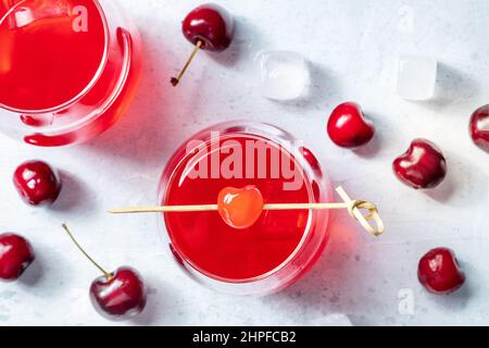 Cocktail con ciliegia e ghiaccio, aperitivo con contorno e frutti di bosco freschi, scatto piatto Foto Stock