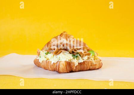 Sandwich con uova strapazzate croccanti e brioched. Foto Stock