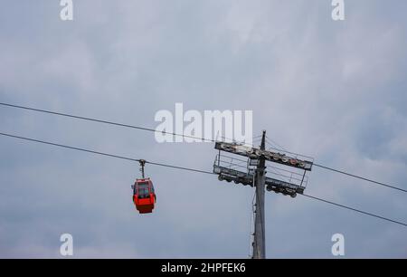 Cabine rosse di funicolare ad Antalya, Turchia sullo sfondo di nuvole di pioggia. Gita in funivia ai punti panoramici delle montagne. Durante il viaggio in funivia i turisti godono di splendide vedute della città e della natura Foto Stock