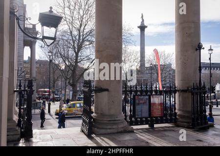 Una vista di Trafalgar Square e della colonna di Nelson vista attraverso le ringhiere alla porta Grande Ovest della chiesa di St Martin-in-the-Fields, il 17th febbraio 2022, a Londra, Inghilterra. Foto Stock