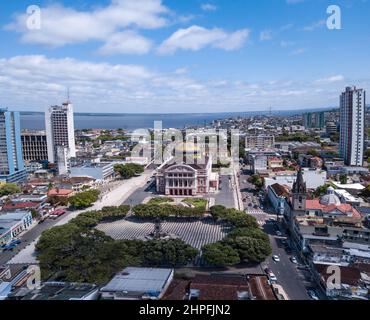 Splendida vista aerea con droni dell'iconico teatro Amazonas e delle case del centro città, edifici e strade nella soleggiata giornata estiva nella foresta pluviale Amazzonica. Brasile Foto Stock