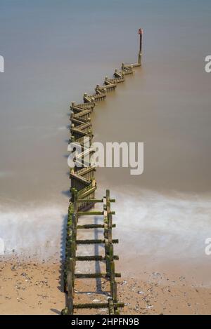 Ammira il Mare del Nord dalla cima della scogliera di Overstrand, Norfolk, Inghilterra, Regno Unito, in una giornata di sole con un groyne dogged in primo piano Foto Stock