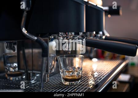Il processo di preparazione dell'espresso in una macchina da caffè professionale, primo piano. Foto Stock