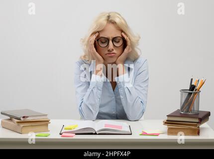 Dipendente infelice. Annoiò giovane donna d'affari seduta sul posto di lavoro, scrivendo note in blocco note Foto Stock