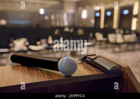 Sul tavolo c'è un microfono sullo sfondo di una sala vuota. Foto Stock