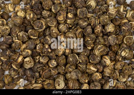 Jasmine Pearls tè verde su sfondo bianco. Tisana medicinale asiatico. Primo piano Foto Stock