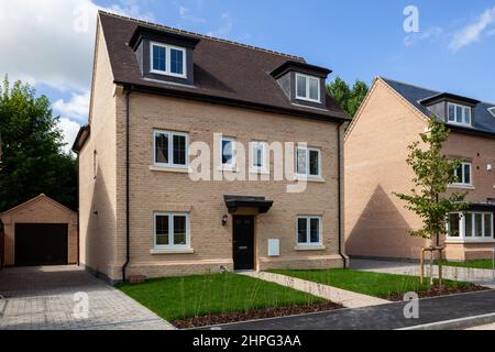 Harston Cambridgeshire - Giugno 29 2011: Costruzione in mattoni di stile tradizionale generico facciata fronte casa nuova con prato al sole. Foto Stock