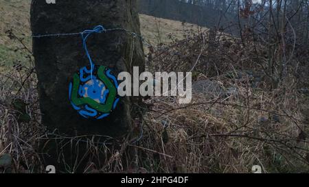 Singoli in vinile, dipinti con disegni astratti, esposti sulla scherma in campagna. Arte di strada Anonimo. Derbyshire. Foto Stock