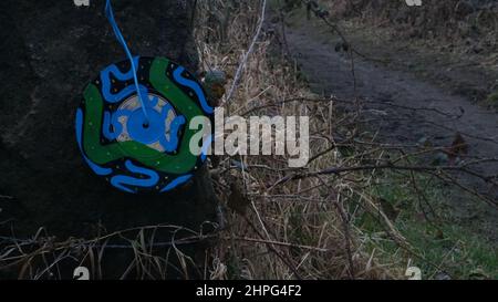 Singoli in vinile, dipinti con disegni astratti, esposti sulla scherma in campagna. Arte di strada Anonimo. Derbyshire. Foto Stock