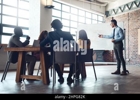 Condividono grandi aspirazioni come team. Scatto di un uomo d'affari maturo che fa una presentazione ai suoi colleghi in un ufficio. Foto Stock