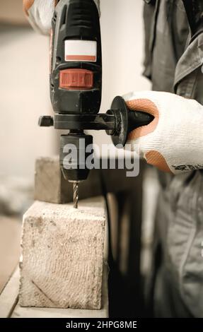 Carpentiere con trapano elettrico per il suo lavoro in carpenteria. Primo piano Foto Stock