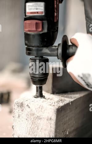 Carpentiere con trapano elettrico per il suo lavoro in carpenteria. Primo piano Foto Stock