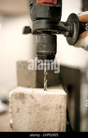 Carpentiere che fora un buco in blocco di legno. Primo piano Foto Stock