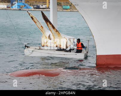 Membro dell'equipaggio Pittura l'ancora su una nave, Valetta Harbour, Malta. Foto Stock