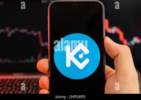 KuCoin Token KCS app di criptovaluta analisi del mercato azionario sullo schermo del telefono cellulare in mani e downtrend grafici di scambio dati sullo sfondo, febbraio 2022, San Francisco, USA. Foto Stock