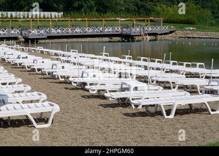 Lettini vuoti allineati sulla spiaggia Foto Stock