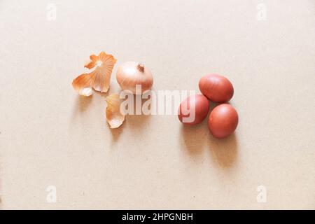 Primo piano delle uova di Pasqua su sfondo sabbioso. Il concetto di colorazione uova con bucce di cipolla, pittura naturale. Vista dall'alto. Con uno spazio da copiare. Foto di alta qualità Foto Stock