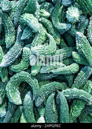 Texture di cetriolo indiano verde. Zucca amara vegetale close up. Verticale. Foto Stock